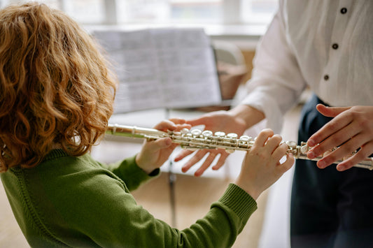 from behind, a boy playing flute