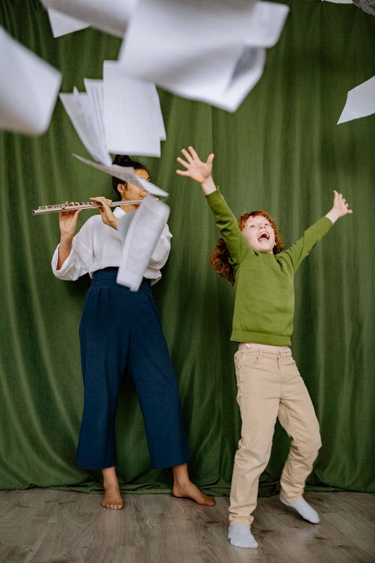 kid throwing sheet music with flute teacher nearby