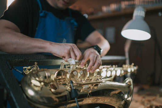 Sax Technician cleaning saxophone keys on a saxophone