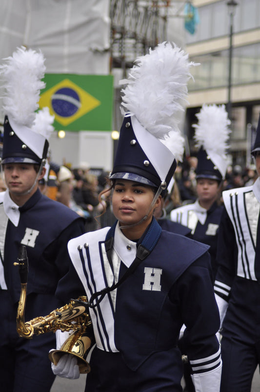 sax boy marching in marching band with feathered hat