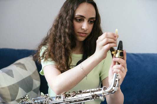 Sax player placing reed on saxophone