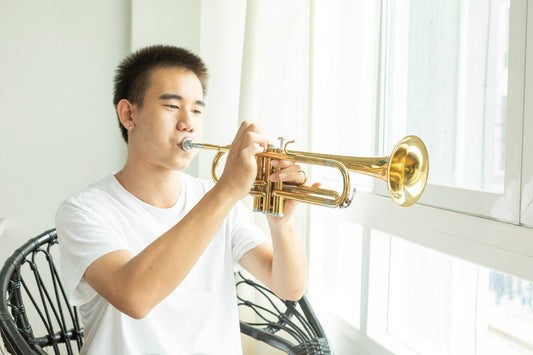 teen boy playing trumpet
