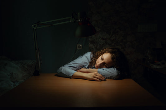 Tired woman with head on her desk