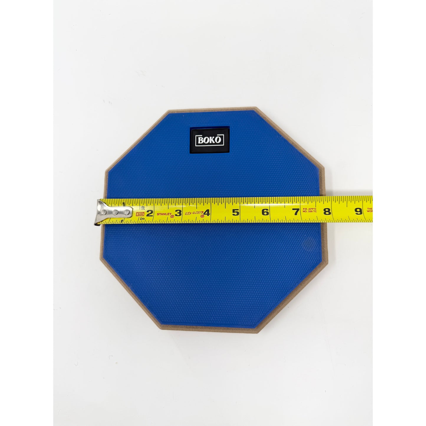 BOKO drum practice pad shown with a tape measure indicating size